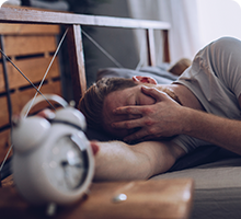 Man unhappy about being woken by an alarm clock